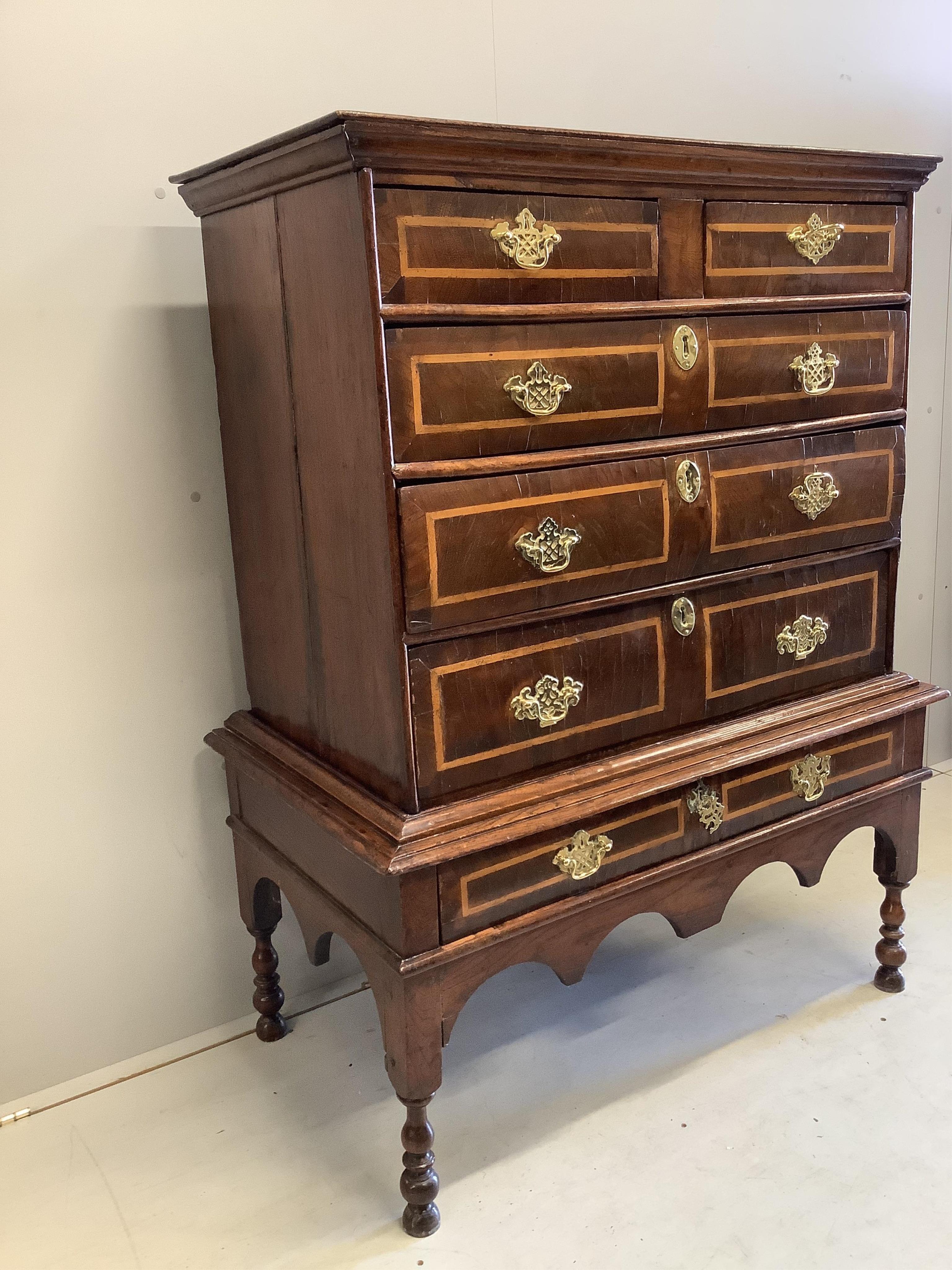 An early Georgian elm, oak and sycamore banded chest on stand, width 98cm, depth 53cm, height 135cm